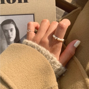 Detail of 925 sterling silver heart ring and freshwater pearl elastic ring on hand