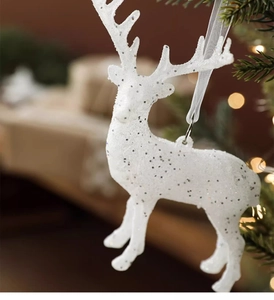 Gros plan du pendentif renne blanc scintillant avec paillettes sur un sapin de Noël