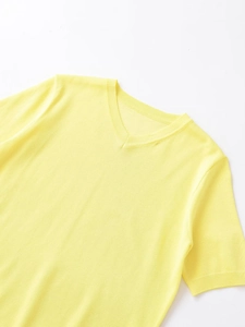 Close-up of the V-neck detail and ribbed knit texture on the yellow short sleeve top