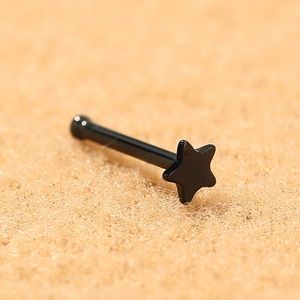 Macro shot of a black star-shaped stainless steel stud earring with a smooth finish