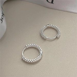 Sparkling 925 sterling silver hoop earrings with fine textured finish on grey surface