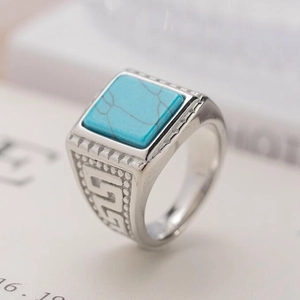 Macro detail of vintage men's ring with square turquoise stone and engraved patterns