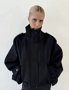 Close-up of black stand-collar jacket with epaulettes and cuff strap details