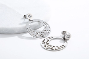 Detailed macro shot of silver star-shaped pendant earrings with sparkling rhinestones