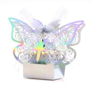Macro detail of laser-cut butterfly candy box with iridescent mirror finish and white ribbon