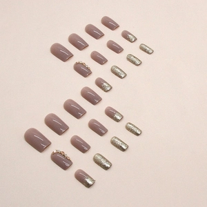 Square long press-on nails with purple glitter, pearls, and rhinestones in S-shape