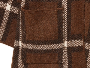 Detailed macro view of checkered knit cardigan showing pocket stitching and brown wool texture