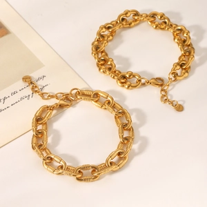 Detail of two 18K gold plated stainless steel bracelets with lobster clasp and tag
