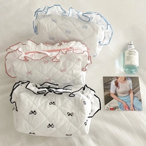 Detailed close-up of quilted cosmetic bags with ruffled edges and bow patterns