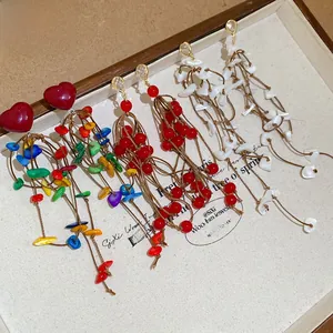 Detailed view of handmade bohemian fringe earrings with acrylic hearts and tassels