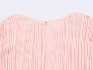 Close-up of pink pleated chiffon dress showing seamless back zipper and fabric texture