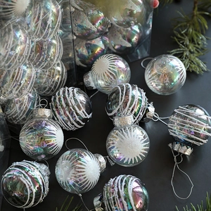 Iridescent 6cm Christmas balls with glitter patterns and silver strings on pine branch