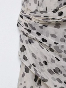 Détail du tissu en mousseline blanche respirante avec motif imprimé à pois noirs irréguliers