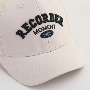Kids cream baseball cap with black embroidered lettering and blue 1983 oval patch