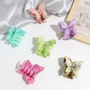 Flat lay of colorful double-layered butterfly hair claws in six gradient marble patterns