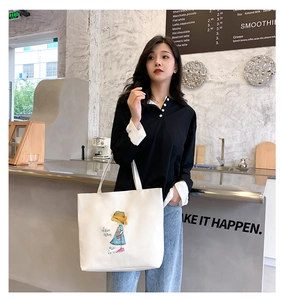Detail of white canvas tote bag with a cartoon girl print and Nice Day text