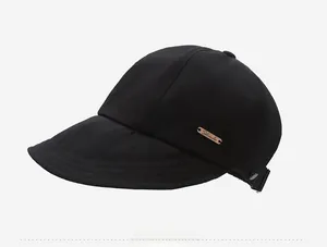 Vue latérale du chapeau pare-soleil en coton noir avec logo ovale en métal bronze