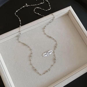 Detailed view of silver crystal bead and pearl necklace on a premium display tray