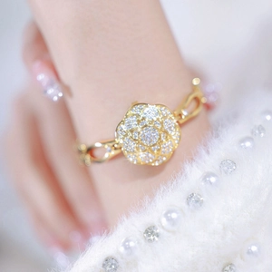 Detailed close-up of a gold floral bracelet watch featuring sparkling zircon inlays