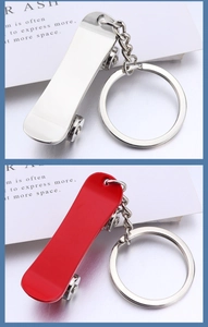 Detail view of mini metal scooter keychains in silver and red with metallic finish