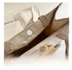 Close-up of the canvas tote bag showing magnetic buckle and internal zipper pocket