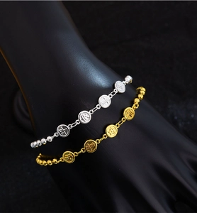 Detailed view of silver and gold beaded bracelets with engraved peace and joy charms