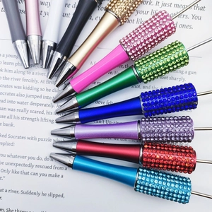 Detailed view of colorful DIY rhinestone beaded pens arranged on an open book background