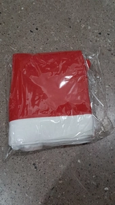 Folded red and white non-woven Christmas chair cover packed in clear plastic bag