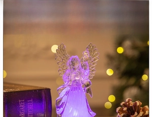 Detail of crystal acrylic angel night light with purple LED glow and festive decorations