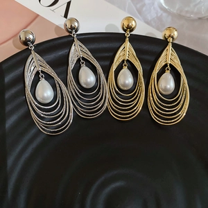 Detailaufnahme mehrlagiger Tropfenohrringe mit Perlen in Gold und Silber