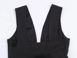 Détail du col en V sur une robe noire sans manches avec texture tissée et finitions soignées