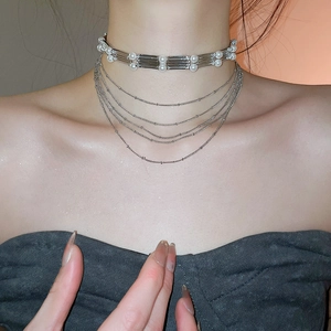 Gros plan d'un collier de perles argentées multicouches avec des éléments métalliques chic