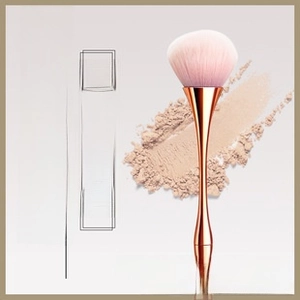 Detail of powder brush with soft pink bristles and rose gold hourglass handle