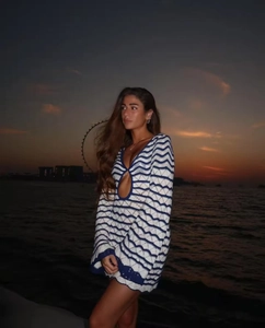 Blau-weißes Häkelkleid mit Wellenmuster und Ausschnitt-Detail im Sonnenuntergang am Meer