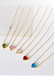 Detail of colorful heart-shaped zircon necklaces on gold-plated titanium steel chains