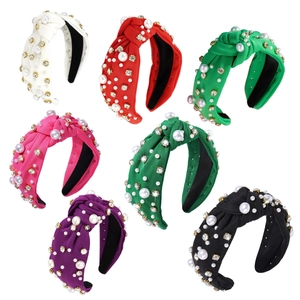 Seven colors of fabric knot headbands with faux pearls and rhinestones on white background