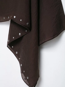 Close-up of brown chiffon fabric with silver metal stud rivets and textured draping