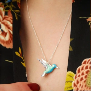 Detail of s925 silver hummingbird pendant with blue gradient enamel and delicate wing textures