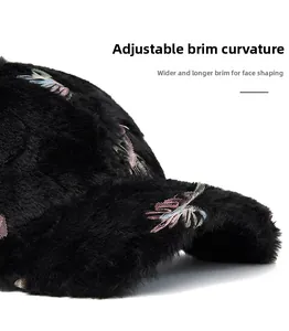 Detail of black plush baseball cap featuring embroidered leaves and foldable wide brim