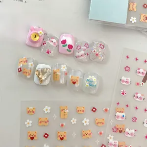 Detailed view of pink handmade press-on nails with bear, cat motifs and 3D heart rhinestones