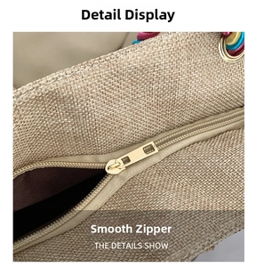 Detail of ethnic style woven bag showing smooth golden metal zipper and colorful braided handle