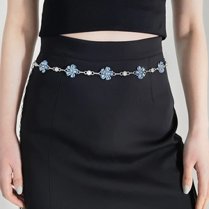 Detail of elegant silver waist chain with blue rhinestone flowers on a model waist