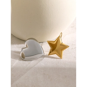 Asymmetric earrings set featuring a silver heart stud and a gold star stud in metallic finish