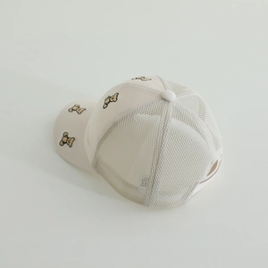 Detail view of the breathable mesh fabric and bear embroidery on the beige kids' sun cap