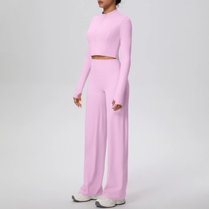 Détail de la veste de sport rose avec passe-pouce et tissu du pantalon de yoga