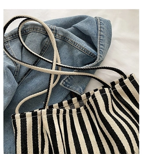 Detail of black and white striped canvas tote with soft braided rope shoulder straps