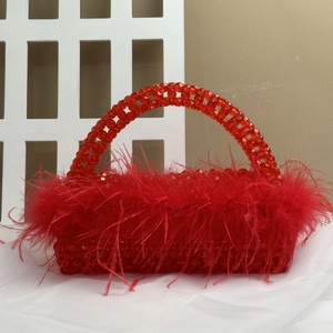 Detailed view of red ostrich feather trim and handmade beadwork on a fashion handbag