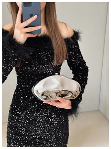 Close-up of silver irregular metallic evening clutch with wavy surface and metal clasp