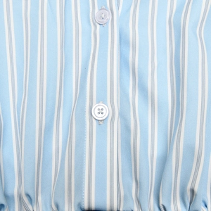 Close-up of light blue and white striped fabric texture with two white buttons