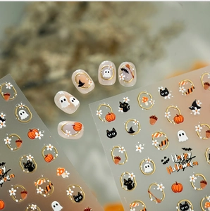 Detail view of Halloween nail stickers featuring gold-trimmed ghosts and black cats